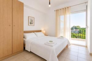 a bedroom with a bed and a large window at E&M Villa Sea View II in Polychrono