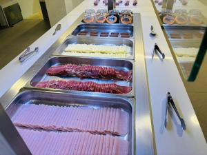 a display counter with trays of different types of meat at Hotel Susuqui in Sanxenxo