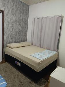 a small bed in a room with a window at Pousada Popular in Barreiras