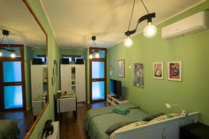 a green bedroom with two beds and a desk at Minicasa Il Salone di Gino in Potenza