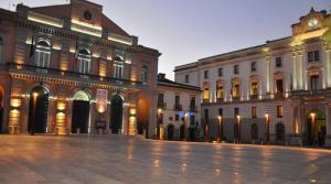 an empty street in front of a building with a clock tower at Minicasa Il Salone di Gino in Potenza