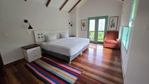 a bedroom with a bed and a chair and a rug at Auka Boutique in Urubamba +24 photos
