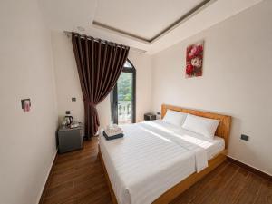 a bedroom with a large bed and a window at Lam Stay Grand World Phu Quoc in Phú Quốc