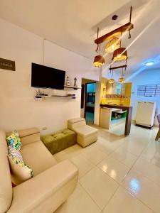 a living room with a couch and a flat screen tv at Cabañas Turísticas Castrolandia in San Antero