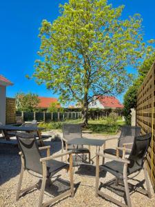 a picnic table and chairs with a tree in the background at Maison Les Sardines in Cucq