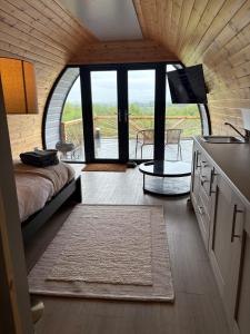a bedroom with a bed and a tv and a balcony at Celtic Glamping in Limerick