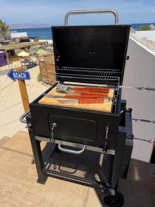 ein Grill, der am Strand steht und Karotten enthält in der Unterkunft Beach Front Lux Containers in La Ventana