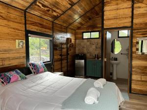 a bedroom with a large bed in a room with wooden walls at Auka Boutique in Urubamba