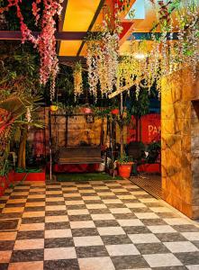 a room with a checkered floor with plants and flowers at Hotel Tushar in Ahmedabad