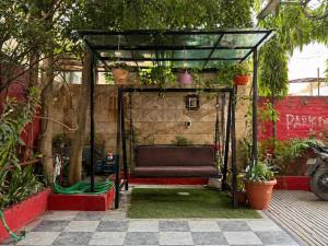 a bench in a garden with plants on it at Hotel Tushar in Ahmedabad
