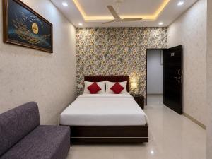a bedroom with a bed and a couch at Hotel Tushar in Ahmedabad +17 photos