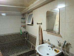 a bathroom with a sink and a mirror at Домик Светланы Ильиничны in Kaji-Say +8 photos