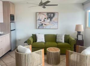 a living room with a green couch and some chairs at Seaside Villa Culebra in Culebra
