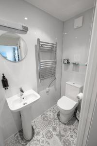 a white bathroom with a toilet and a sink at Kingsway Guesthouse - A selection of Single, Double and Family Rooms in a Central Location in Scarborough +47 photos