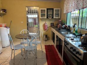 a kitchen with a table and chairs and a sink at Studio Funcional in Guaraqueçaba