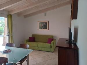 a living room with a green couch and a table at Sole e Sale in Sardegna in Pula