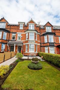 a large brick building with a garden in front of it at Kingsway Guesthouse - A selection of Single, Double and Family Rooms in a Central Location in Scarborough