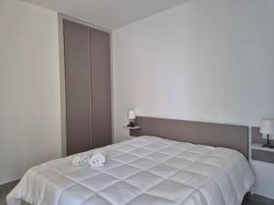 a bedroom with a white bed with two towels on it at Pitagora Residence in Metaponto +53 photos