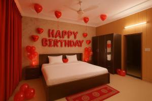 a bedroom with a bed with balloons and a happy birthday sign at The Royal Palace in Lucknow