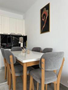 a dining room table with gray chairs and a white table at Prime Rooms Tirana in Tirana