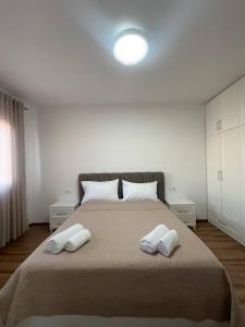 a bedroom with a large bed with two white pillows at Prime Rooms Tirana in Tirana