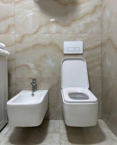 a bathroom with a toilet and a sink at Prime Rooms Tirana in Tirana