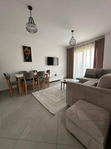a living room with a couch and a table and chairs at Prime Rooms Tirana in Tirana