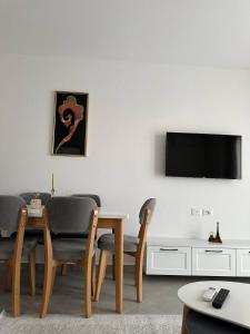 a living room with a table and chairs and a tv at Prime Rooms Tirana in Tirana +5 photos