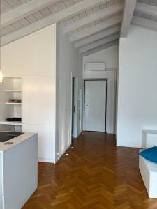 a kitchen with white cabinets and a wooden floor at Dream View Lake Como in Carate Urio +15 photos
