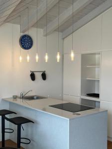 a kitchen with a sink and a counter with stools at Dream View Lake Como in Carate Urio