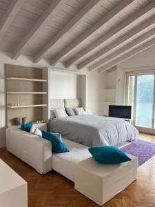 a bedroom with a large white bed and blue pillows at Dream View Lake Como in Carate Urio