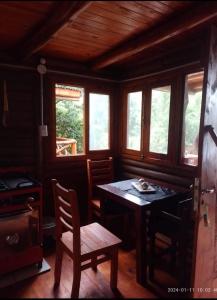 a dining room with a table and chairs and windows at Amphu colibri in La Falda +3 photos