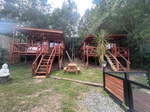 a resort cabin with wooden stairs and a fence at Amphu colibri in La Falda