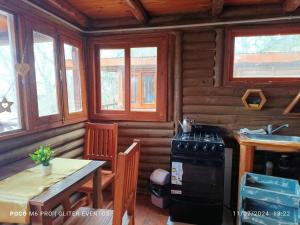 a kitchen with a table and a stove in a cabin at Amphu colibri in La Falda