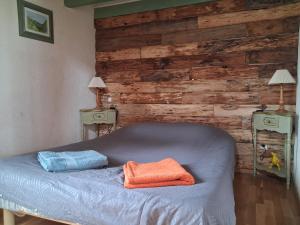 a bed with two towels on it in a room at L'Oursonnière de la Rende in Quérigut