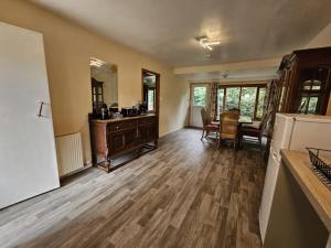 a living room with wooden floors and a dining room at Cottage - Sleeps 5 - Garden - River Side in Garve