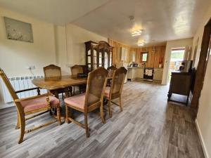 a dining room with a wooden table and chairs at Cottage - Sleeps 5 - Garden - River Side in Garve +6 photos