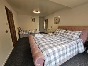 a bedroom with a large bed and a couch at Cottage - Sleeps 5 - Garden - River Side in Garve