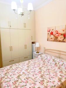 a bedroom with a bed and white cabinets at Maira's place Corfu in Corfu