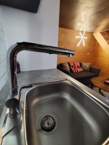 a sink in a kitchen with a couch in a room at L'instant parental in Ustou +29 photos