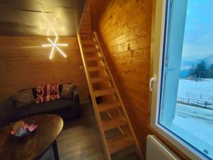 a room with a ladder and a couch and a window at L'instant parental in Ustou
