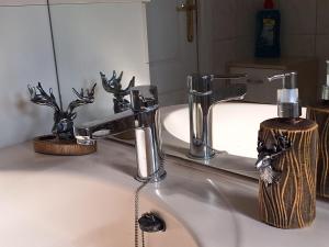 a bathroom sink with a faucet and a soap dispenser at Happy Place is een modern en comfortabel chalet met een grote afgesloten tuin op de Veluwe, Recreatiepark De oude Driest in Putten +58 photos