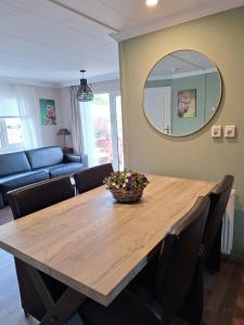 a dining room table with chairs and a mirror at Happy Place is een modern en comfortabel chalet met een grote afgesloten tuin op de Veluwe, Recreatiepark De oude Driest in Putten