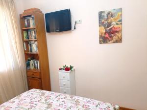 a bedroom with a bed and a tv on the wall at Maira's place Corfu in Corfu