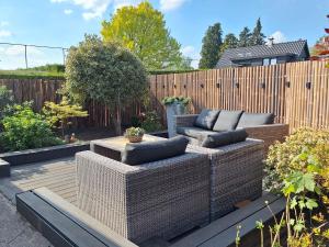 a garden with two couches and a wooden fence at Happy Place is een modern en comfortabel chalet met een grote afgesloten tuin op de Veluwe, Recreatiepark De oude Driest in Putten