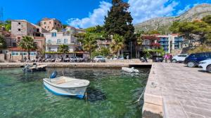 a boat in the water next to a street at Villa Porto in Mlini
