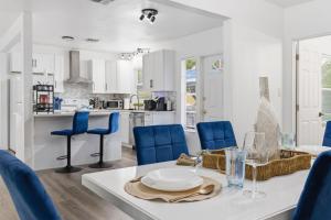 a kitchen and dining room with a table and blue chairs at Clearwater Paradise w Hot Tub-Backyard Bliss Near Beach & Hot Spots in Clearwater