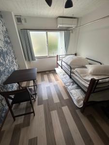 a bedroom with two beds and a desk and a chair at 東尋坊近く自転車無料 コンビニ目の前1ルーム貸切 in Mikuni