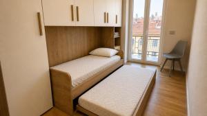 a small room with two beds and a window at Attico Matteotti Sanremo Luxury Terrace Apartment in Sanremo