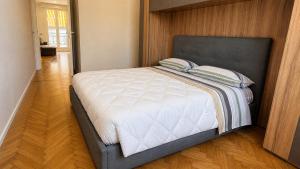 a large bed in a bedroom with a wooden floor at Attico Matteotti Sanremo Luxury Terrace Apartment in Sanremo